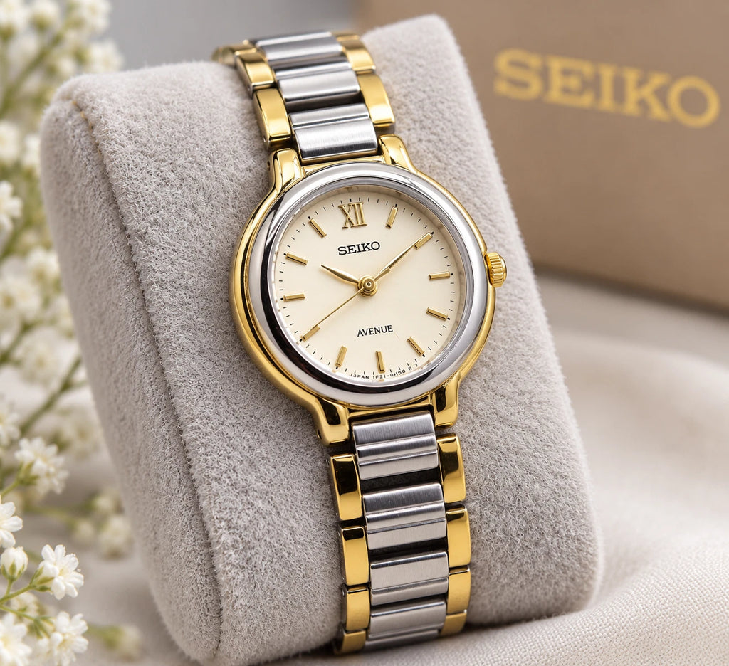 Sapphire Seiko Avenue 1F21-0H50 ladies’ quartz two-tone watch with gold accents, displayed on branded cushion.