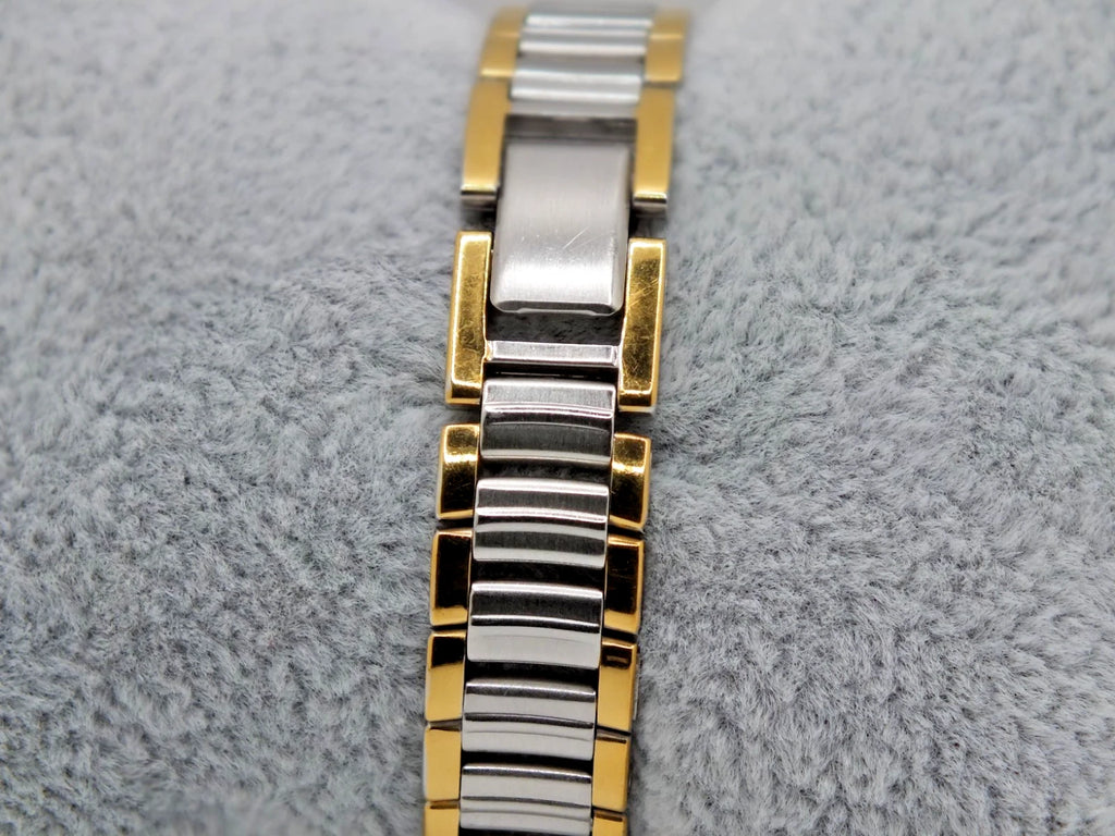 Seiko Avenue 1F21-0H50 ladies’ quartz two-tone watch with gold accents on silver band, displayed on gray textured surface.