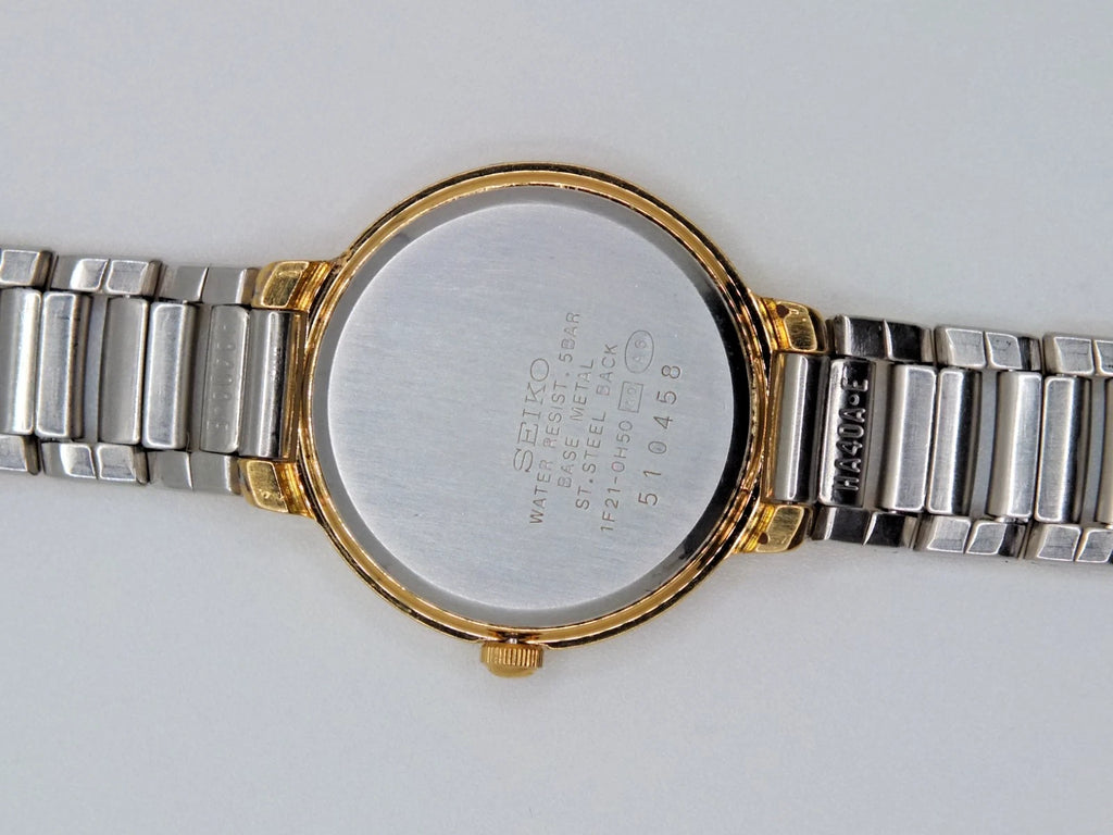 Sapphire Seiko Avenue 1F21-0H50 ladies quartz two tone watch with gold-tone dial, silver hour markers, and printed text.