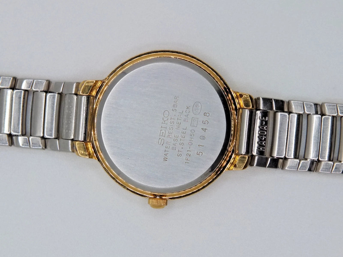 Sapphire Seiko Avenue 1F21-0H50 ladies quartz two tone watch with gold-tone dial, silver hour markers, and printed text.