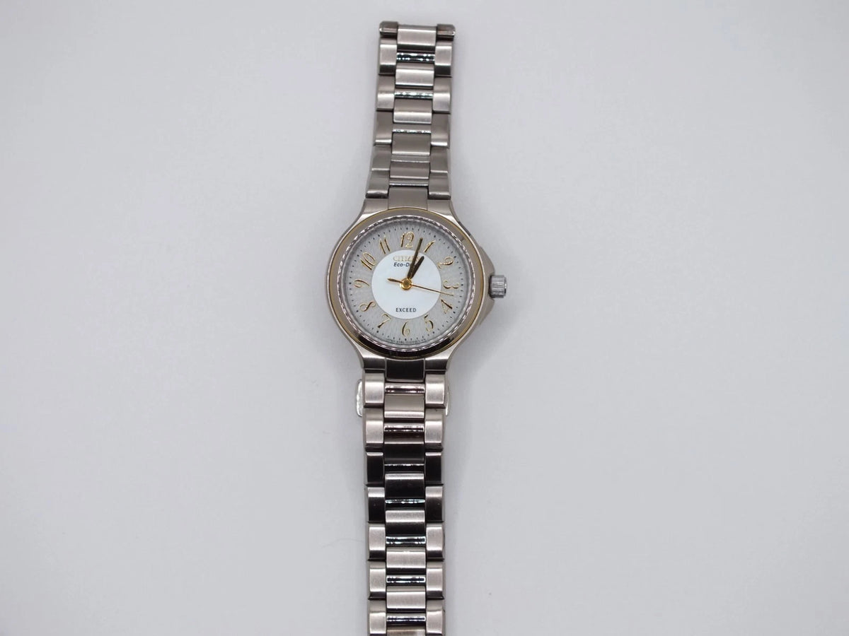 Silver and gold two-tone Seiko Avenue 1F21-0H50 ladies’ quartz watch with gold dial, black hour markers, and linked metal band.