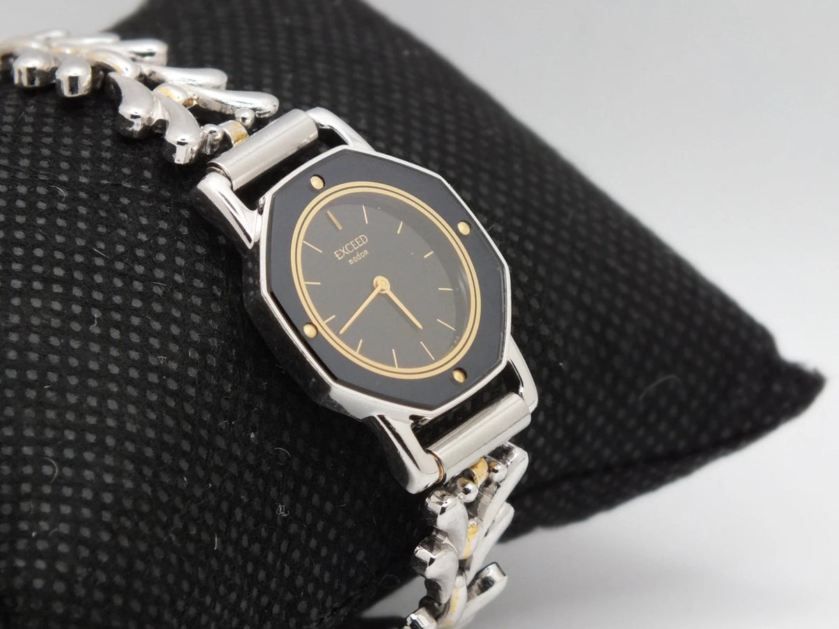 Silver and black vintage Citizen Exceed women’s quartz bracelet with gold accents and “EXCEED 2200-223081” text.
