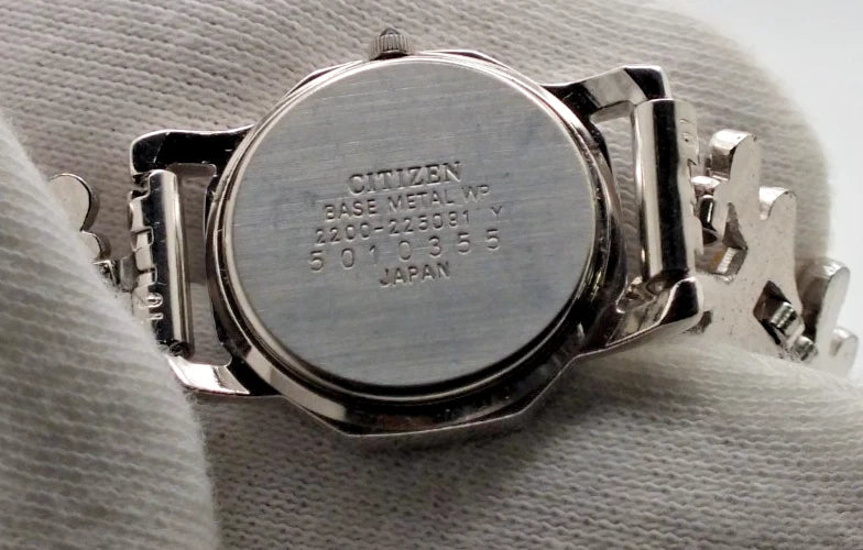 Silver-tone vintage Citizen Exceed women’s quartz black dial bracelet with engraved text and case markings.