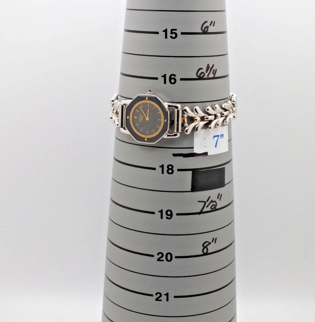 Silver-tone vintage Citizen Exceed women’s quartz black dial bracelet with 7-inch band, shown beside measurement grid.
