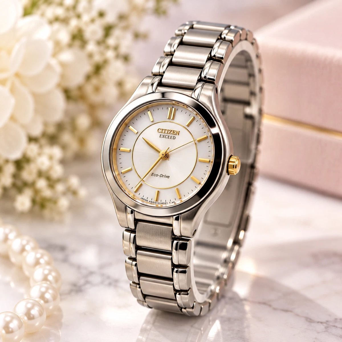 Silver Citizen Exceed A930 Eco-Drive women’s watch with white pearl dial, gold hour markers, and linked metal band.