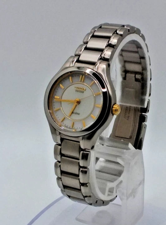 Silver titanium Citizen Exceed A930 watch with gold pearl dial, silver hour markers, and linked metal band.