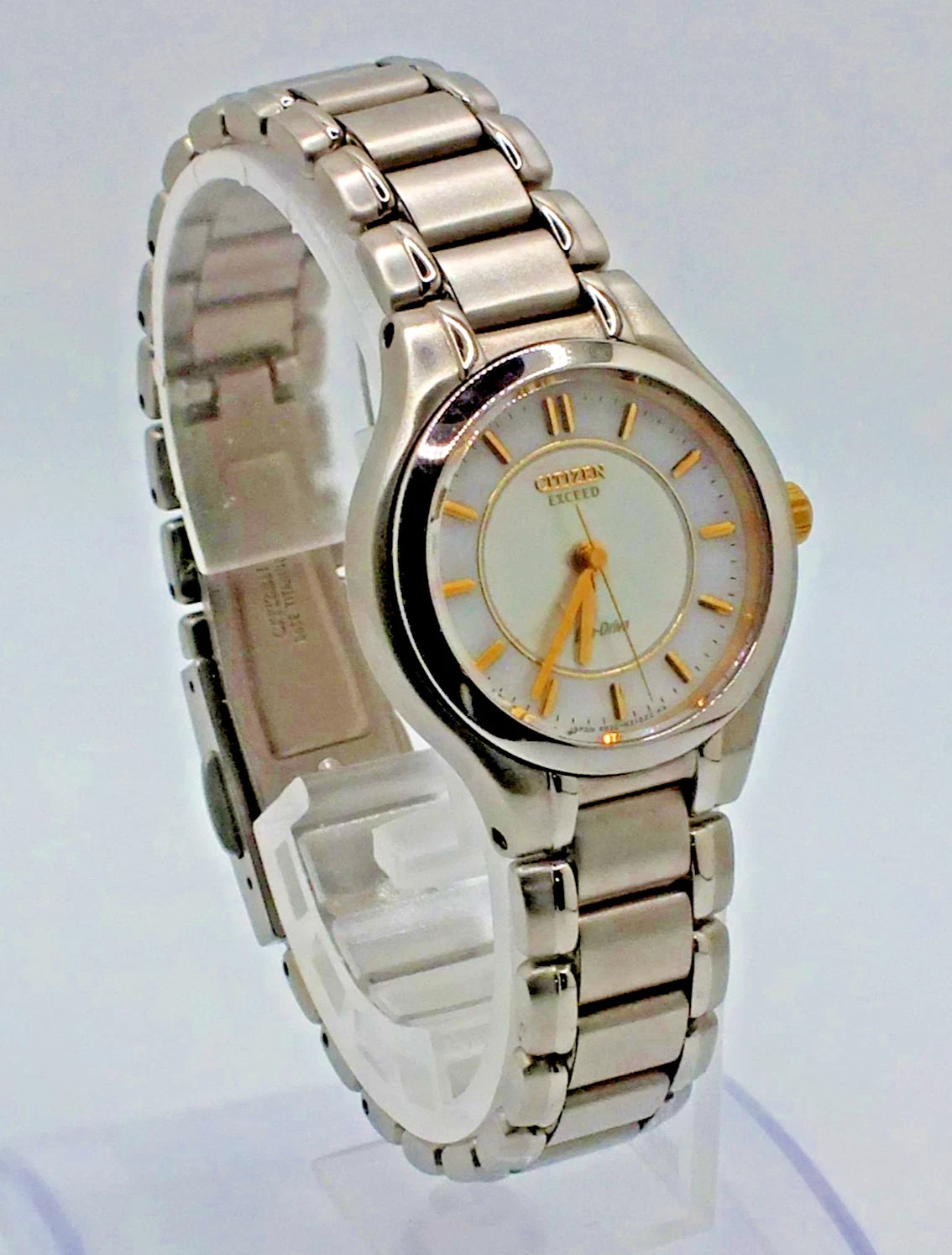 Silver titanium Citizen Exceed A930 watch with gold pearl dial, silver hour markers, and linked metal band.