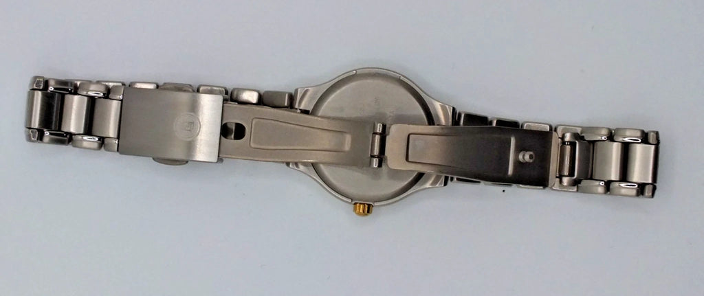 Silver titanium Citizen Exceed A930 watch with gold pearl dial, black hour markers, and stainless steel bracelet with dual clasp.