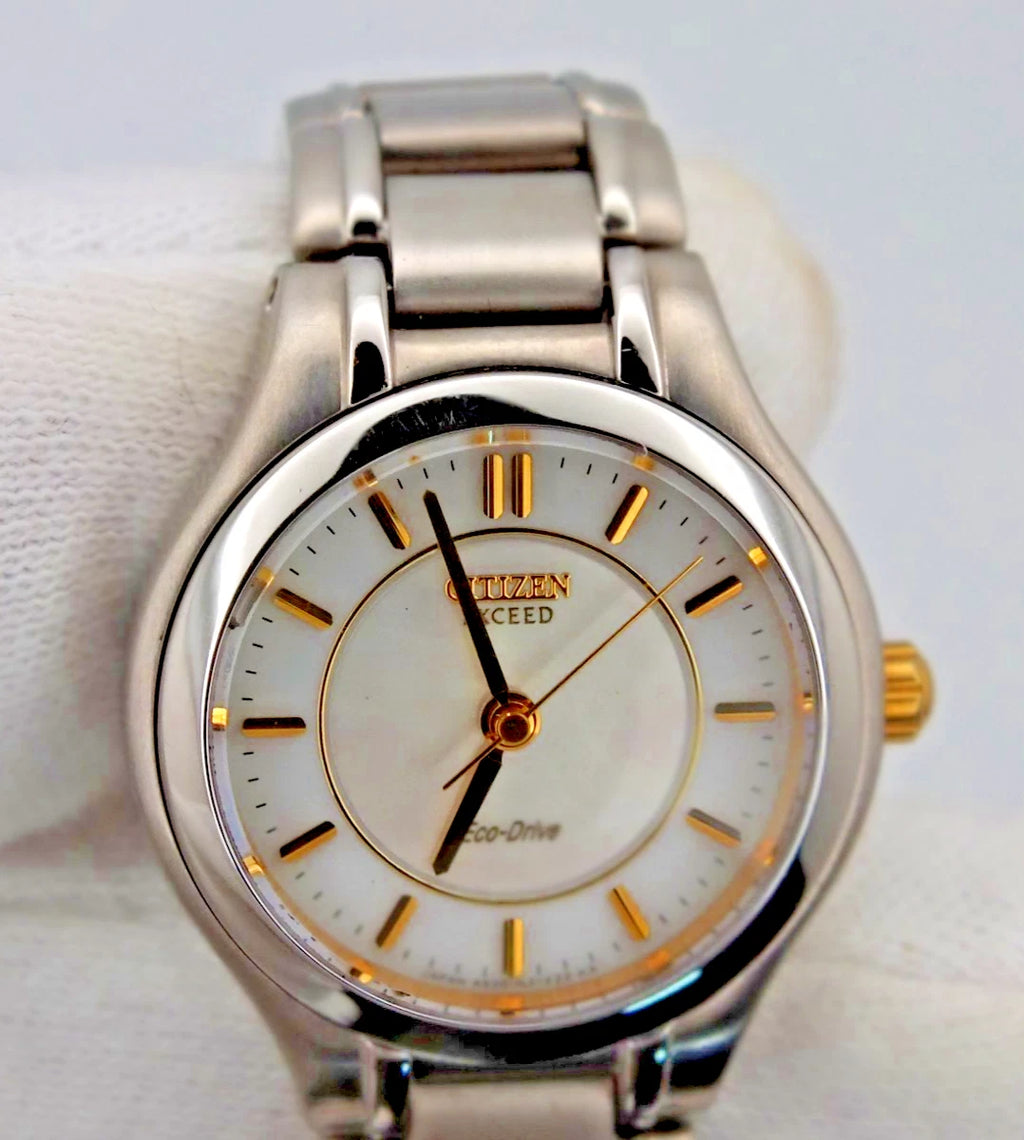 Silver Citizen Exceed A930 watch with gold pearl dial, black hour markers, and “Eco-Drive” text on luminous black case.