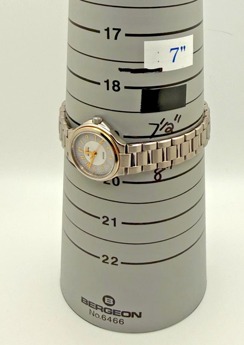 Silver Citizen Exceed A930 watch with gold pearl dial, black hour markers, and “Breguet” text on white metal band.